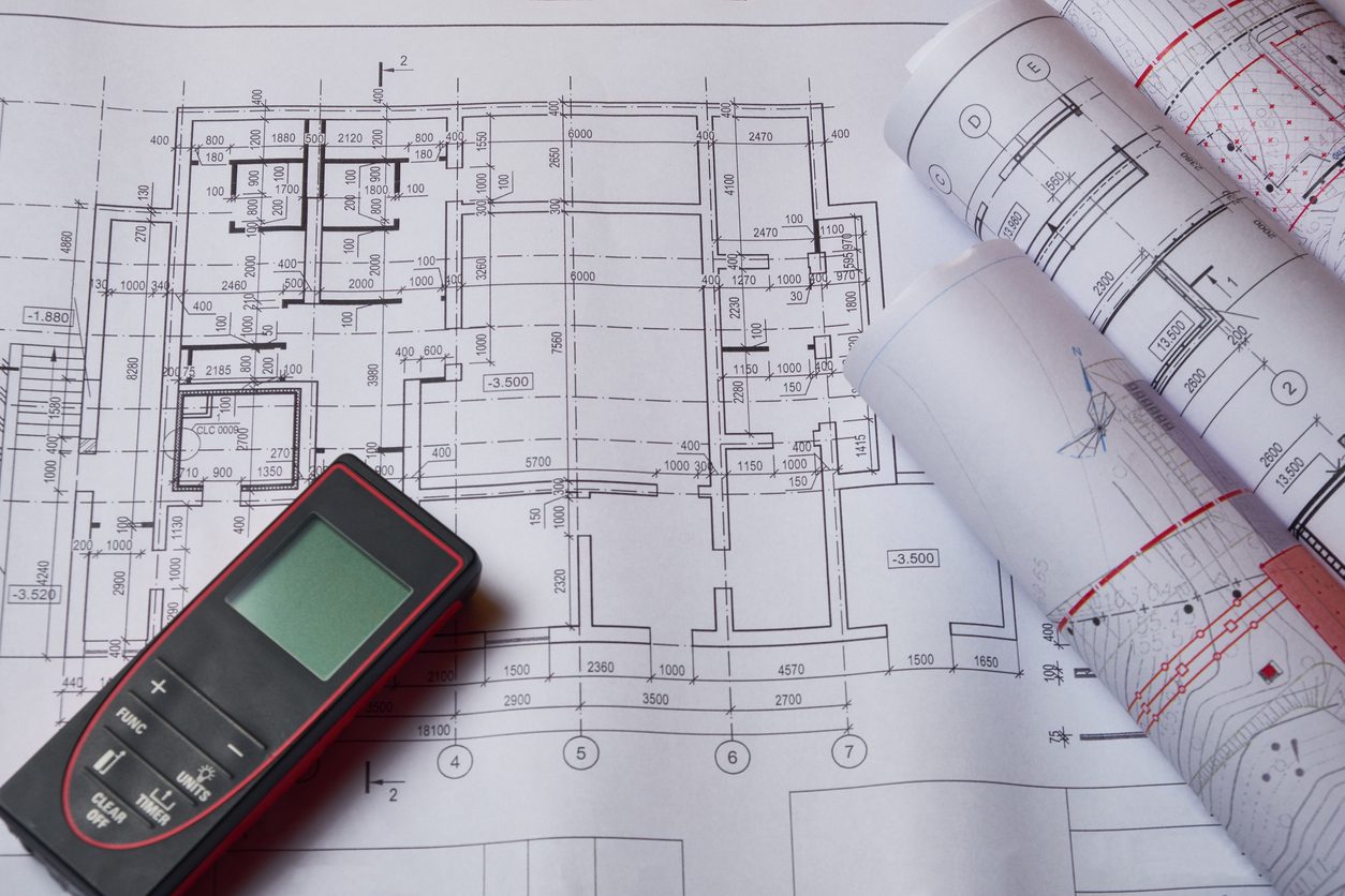 Laser meter and drawings at engineer workplace.